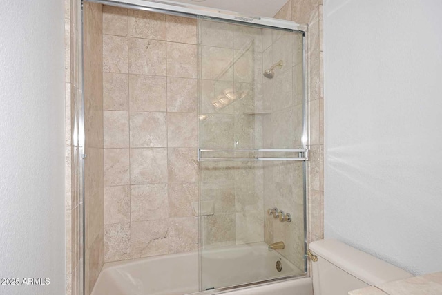 bathroom featuring enclosed tub / shower combo and toilet