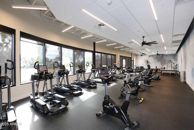 gym featuring ceiling fan and a paneled ceiling