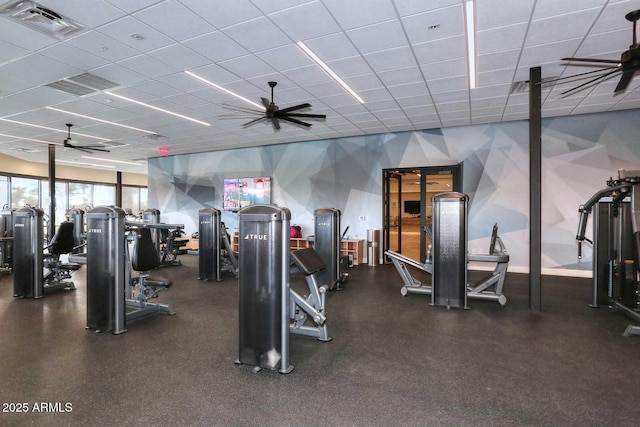 workout area with a paneled ceiling and ceiling fan