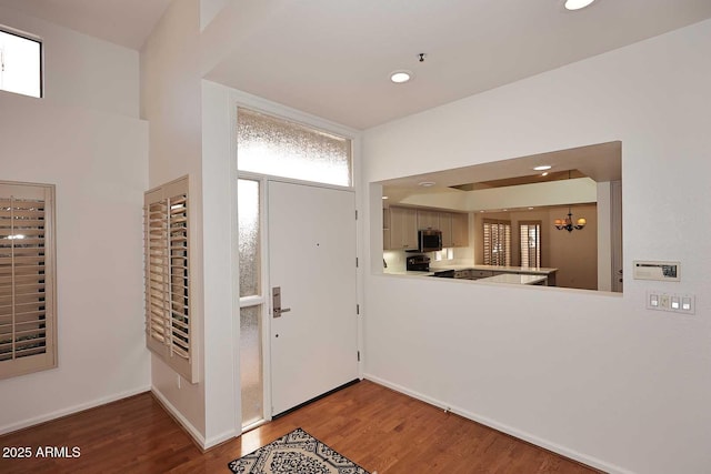 entryway featuring dark hardwood / wood-style flooring and a chandelier