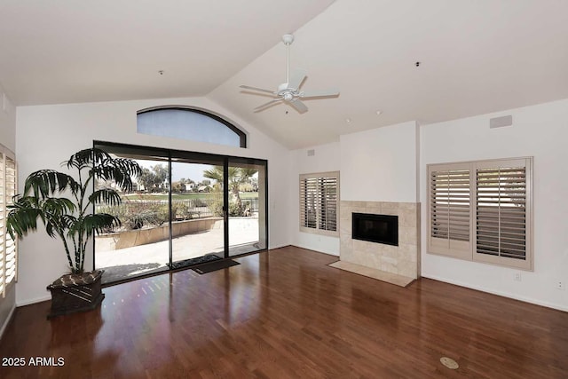 unfurnished living room featuring a tiled fireplace, high vaulted ceiling, dark hardwood / wood-style floors, and ceiling fan