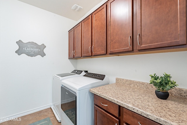 laundry area with visible vents, light tile patterned flooring, baseboards, cabinet space, and washer and clothes dryer