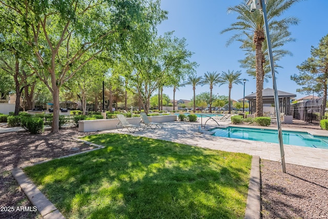 community pool with a patio area, a gazebo, a yard, and fence