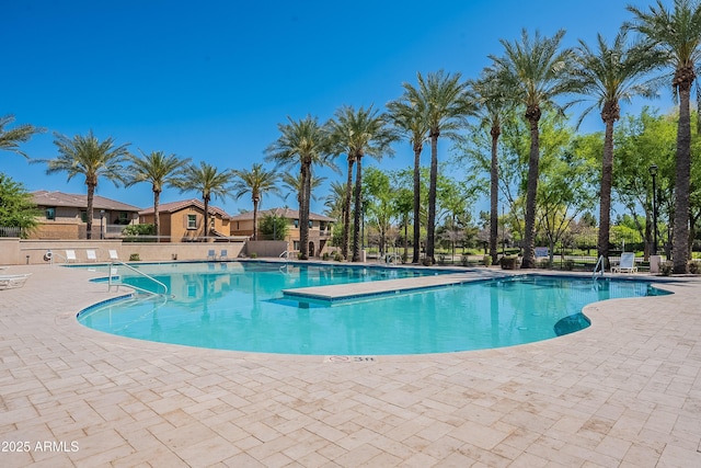 community pool featuring a patio and fence
