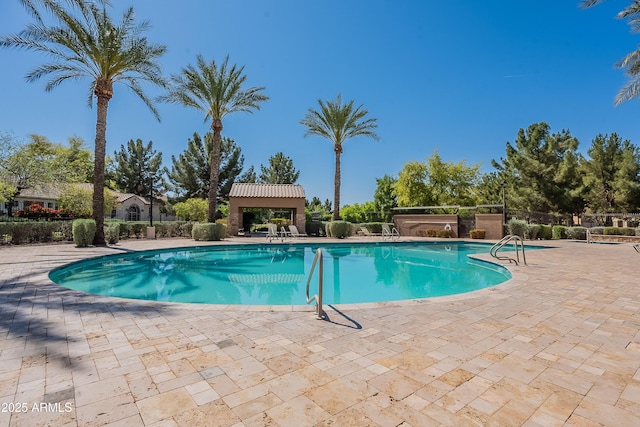 community pool with a patio and fence