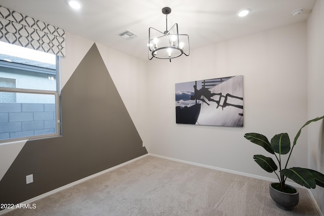 empty room featuring carpet, visible vents, baseboards, and a notable chandelier