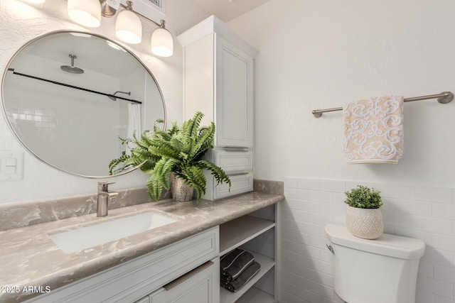 bathroom featuring curtained shower, toilet, a wainscoted wall, vanity, and tile walls