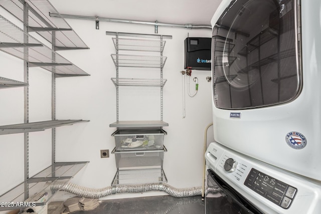 laundry area with stacked washer and dryer and laundry area