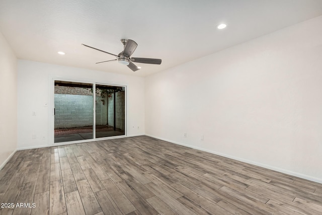 empty room with ceiling fan, recessed lighting, wood finished floors, and baseboards