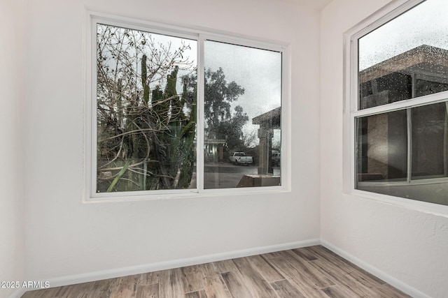 empty room featuring wood finished floors and baseboards