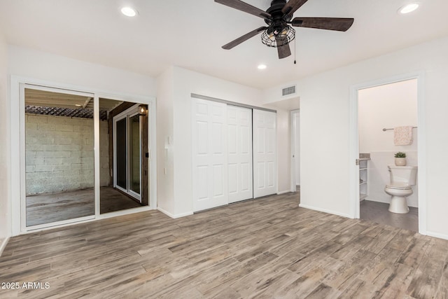 unfurnished bedroom featuring ensuite bathroom, recessed lighting, wood finished floors, visible vents, and baseboards