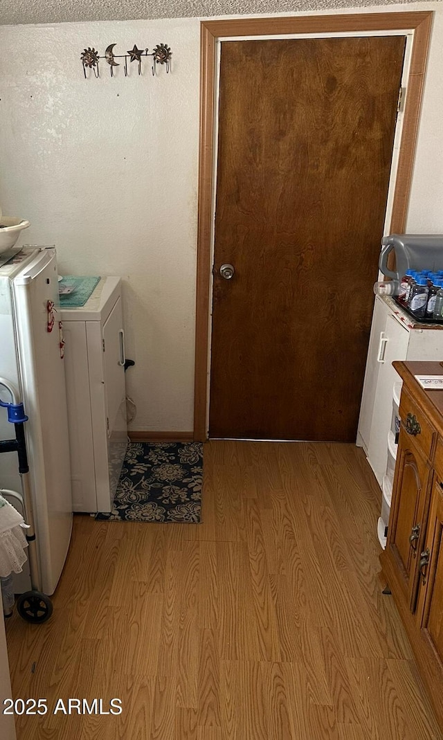 laundry area with laundry area, washer / clothes dryer, and light wood-type flooring