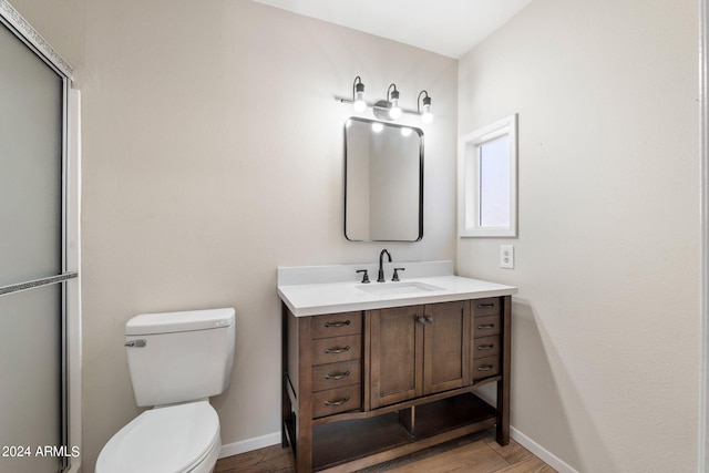 bathroom with toilet, walk in shower, hardwood / wood-style flooring, and vanity