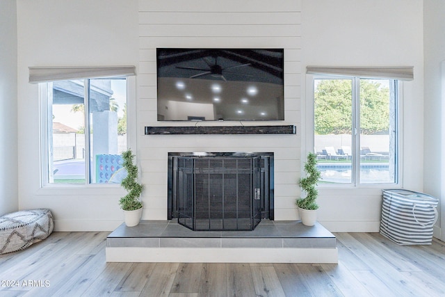 room details with a tile fireplace, ceiling fan, and hardwood / wood-style flooring