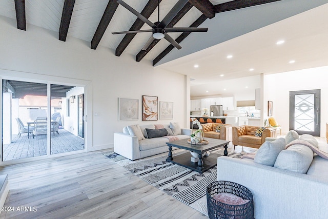 living room featuring ceiling fan, sink, beam ceiling, high vaulted ceiling, and light hardwood / wood-style flooring