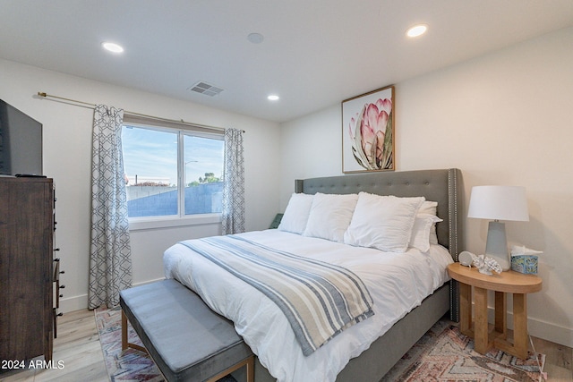 bedroom featuring a water view and light wood-type flooring