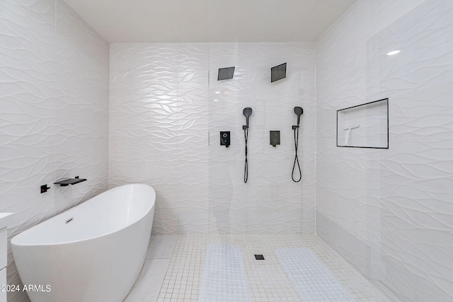 bathroom featuring shower with separate bathtub and tile walls