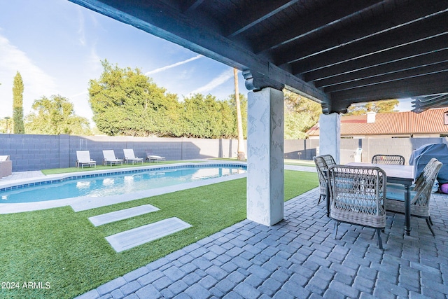 view of swimming pool with a yard and a patio