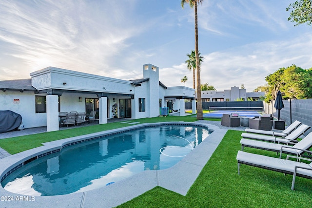 view of pool featuring a yard, an outdoor living space, and a patio area