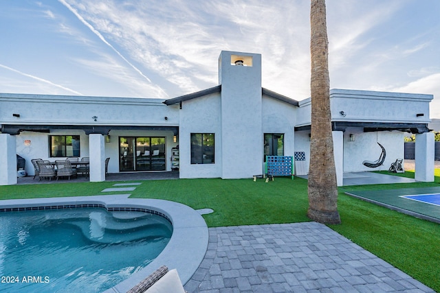 rear view of property with a lawn and a patio