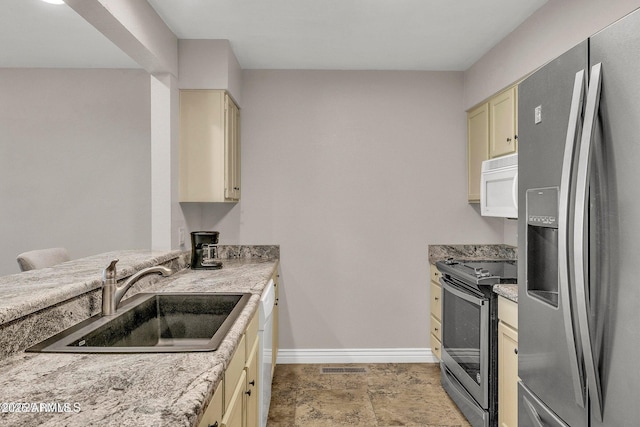 2800 N Saddleback Way Unit 2, Flagstaff, AZ 86004 - kitchen with a sink, appliances with stainless steel finishes, visible vents, baseboards, and cream cabinetry