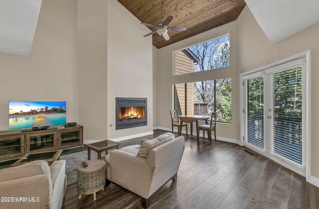 2800 N Saddleback Way Unit 2, Flagstaff, AZ 86004 - living room featuring dark wood-style flooring, a warm lit fireplace, high vaulted ceiling, a ceiling fan, and baseboards