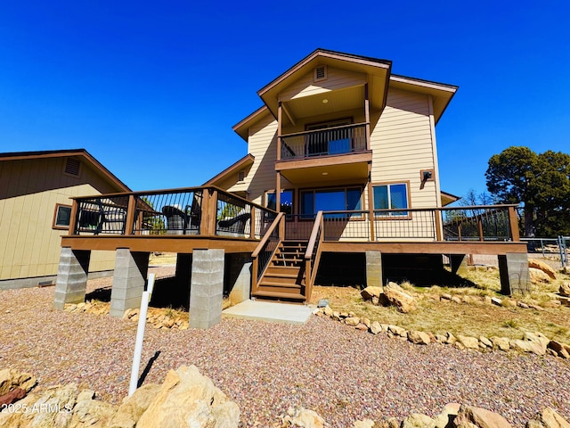 view of front of house featuring a deck, stairs, and a balcony