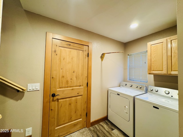 laundry room featuring baseboards, cabinet space, light wood-style floors, and washing machine and dryer