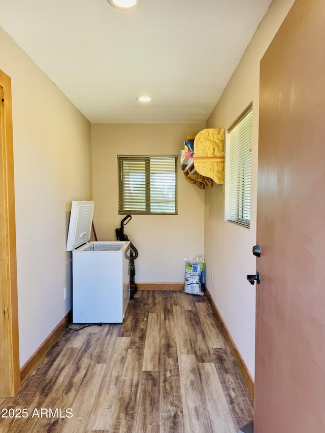 laundry room with baseboards and wood finished floors