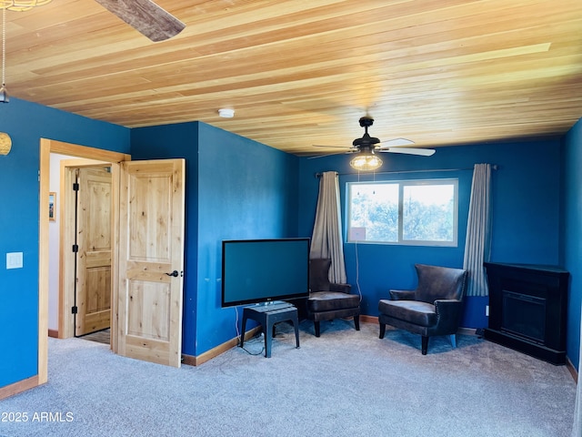 sitting room featuring wooden ceiling, baseboards, carpet, and a ceiling fan