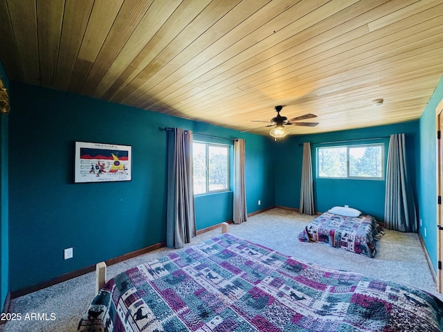 carpeted bedroom featuring baseboards, wooden ceiling, and a ceiling fan