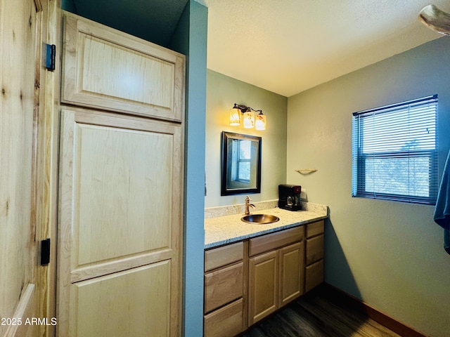 bathroom featuring vanity, baseboards, and wood finished floors