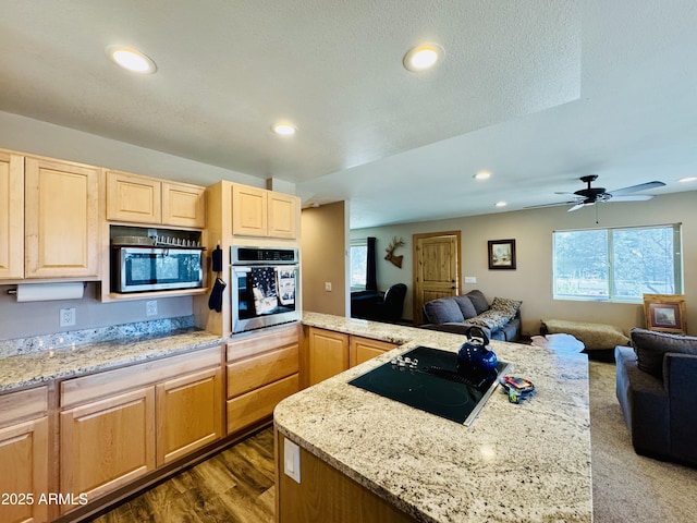 kitchen with recessed lighting, open floor plan, appliances with stainless steel finishes, and light brown cabinetry