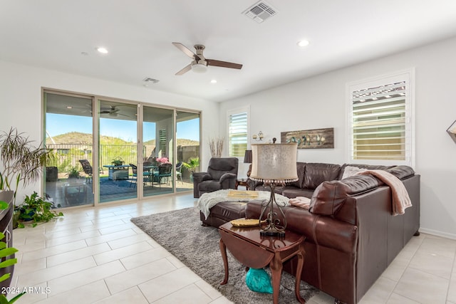 living room featuring light tile patterned floors, ceiling fan, and plenty of natural light