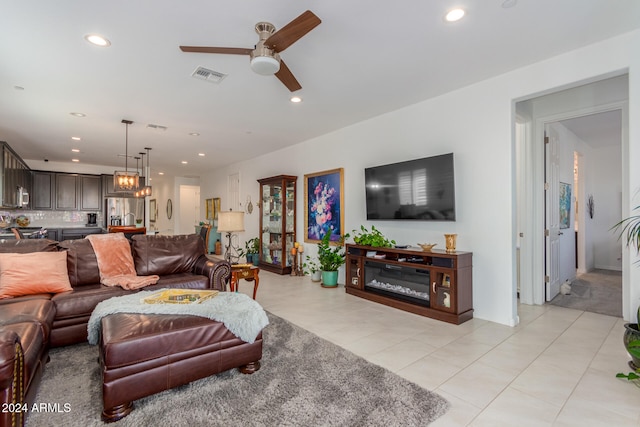 living room with ceiling fan with notable chandelier and light tile patterned flooring