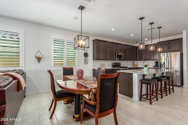 tiled dining space featuring a chandelier and sink