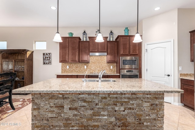 kitchen featuring appliances with stainless steel finishes, hanging light fixtures, light tile patterned floors, and sink