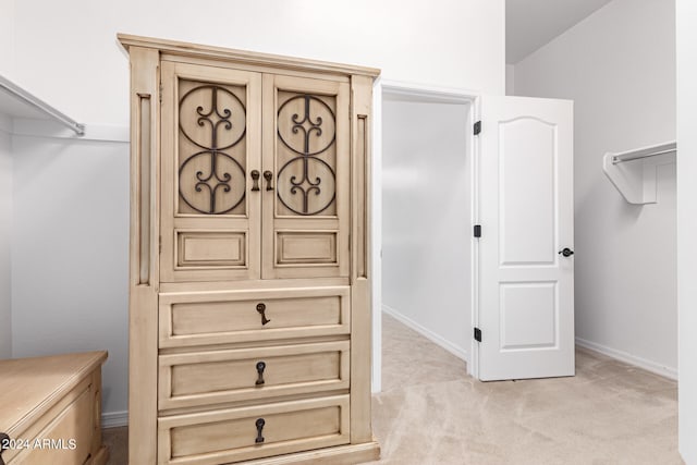 spacious closet with vaulted ceiling and light carpet