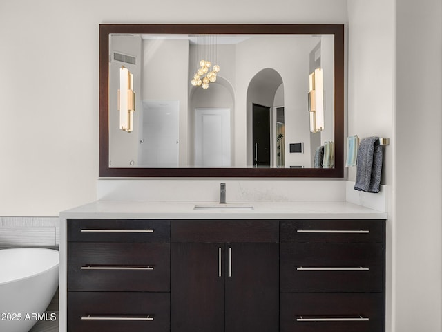 full bath with a soaking tub, visible vents, and vanity