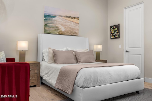 bedroom featuring baseboards and light wood finished floors