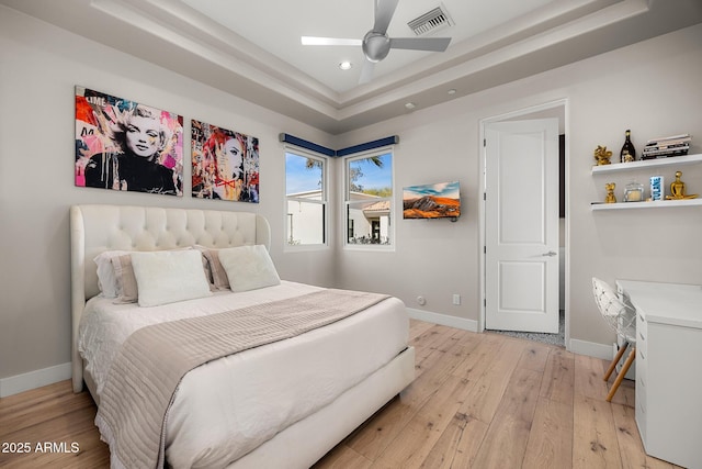 bedroom with recessed lighting, a raised ceiling, visible vents, light wood-style floors, and baseboards