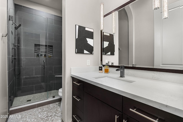 bathroom featuring a stall shower, vanity, and toilet