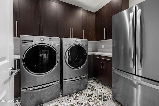 laundry room featuring light tile patterned floors, independent washer and dryer, and cabinet space