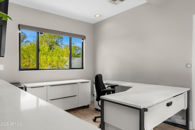 home office featuring light wood-type flooring and visible vents