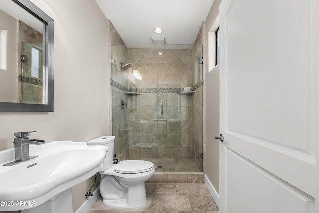 bathroom with toilet, stone tile flooring, a shower stall, a sink, and recessed lighting