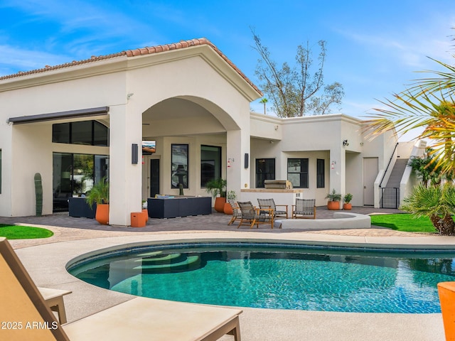 back of house featuring stucco siding, a patio area, exterior bar, an outdoor pool, and an outdoor living space