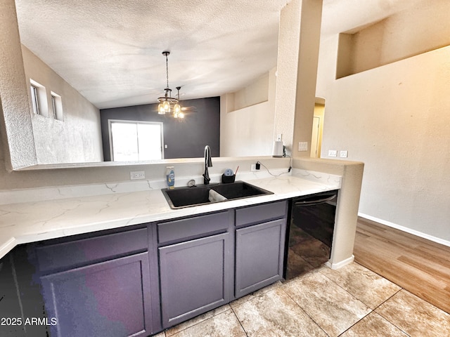 kitchen with a sink, dishwasher, lofted ceiling, gray cabinetry, and a chandelier