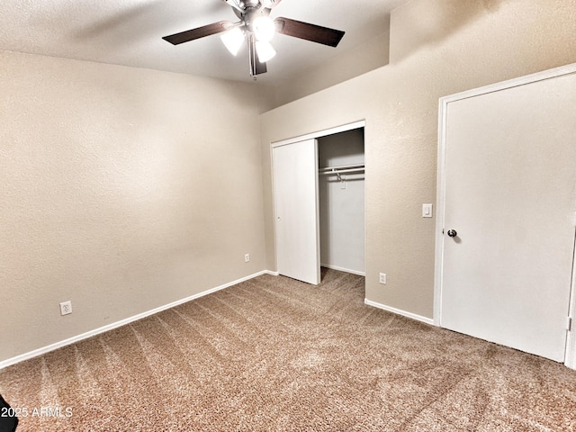 unfurnished bedroom with carpet, a closet, a ceiling fan, baseboards, and a textured wall