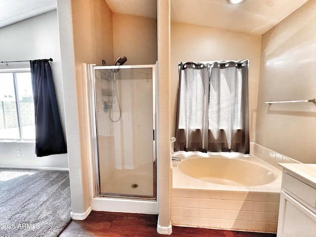 full bath with a shower stall, a bath, wood finished floors, and vanity