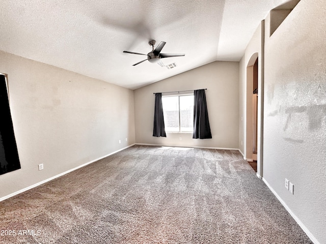 spare room featuring ceiling fan, lofted ceiling, carpet floors, a textured ceiling, and baseboards